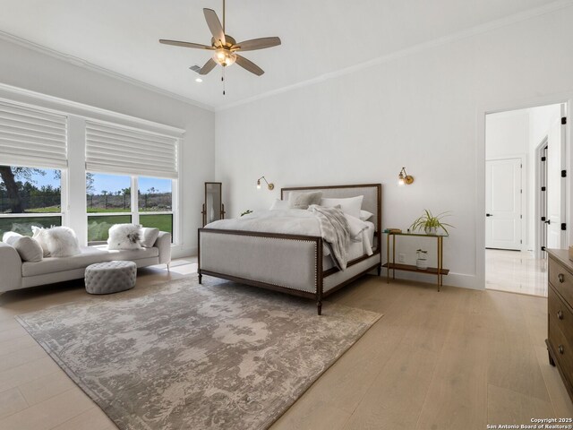 bedroom featuring baseboards, ceiling fan, ornamental molding, and light wood-style flooring