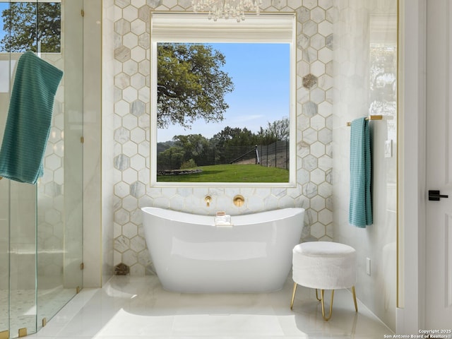 bathroom featuring a freestanding tub, tile walls, and tile patterned flooring