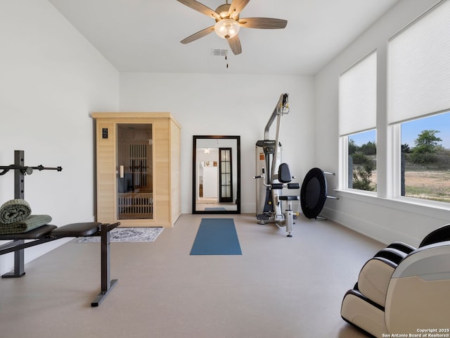 exercise area featuring visible vents, a ceiling fan, and baseboards