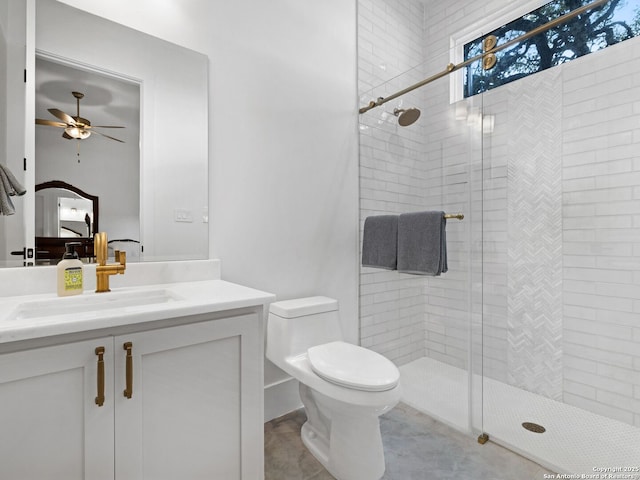 bathroom featuring vanity, toilet, a ceiling fan, and a stall shower