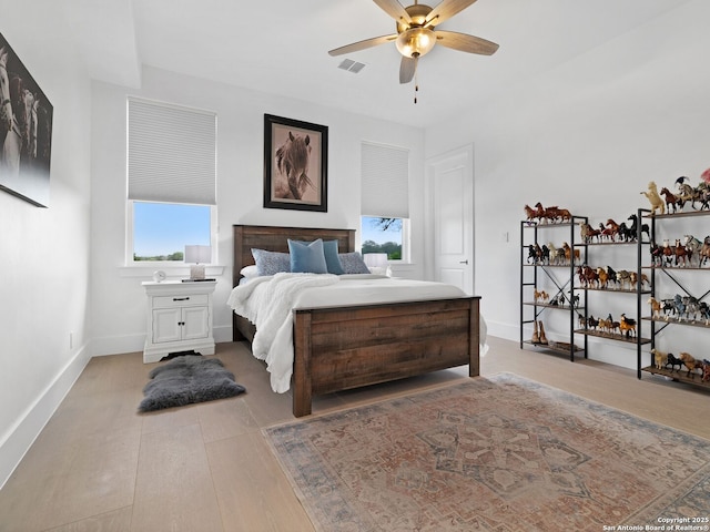bedroom featuring baseboards, a ceiling fan, light wood-style flooring, and visible vents