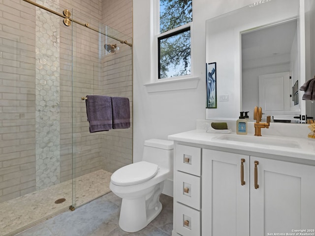 bathroom with toilet, a tile shower, tile patterned flooring, and vanity