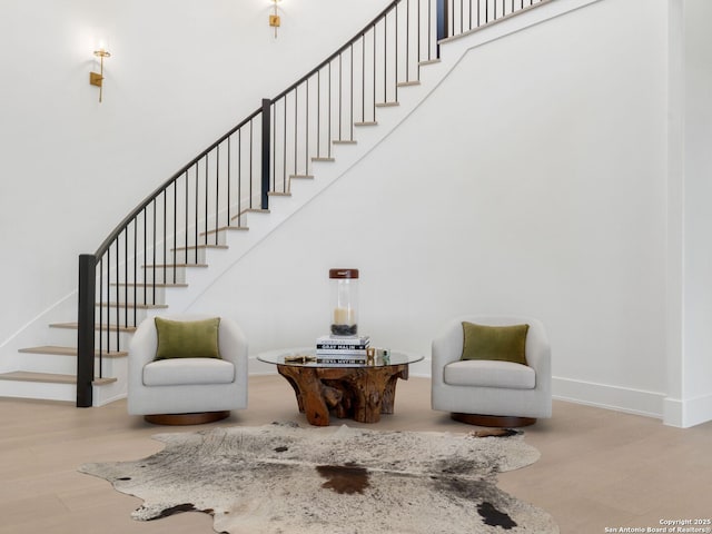 living area with baseboards and stairs