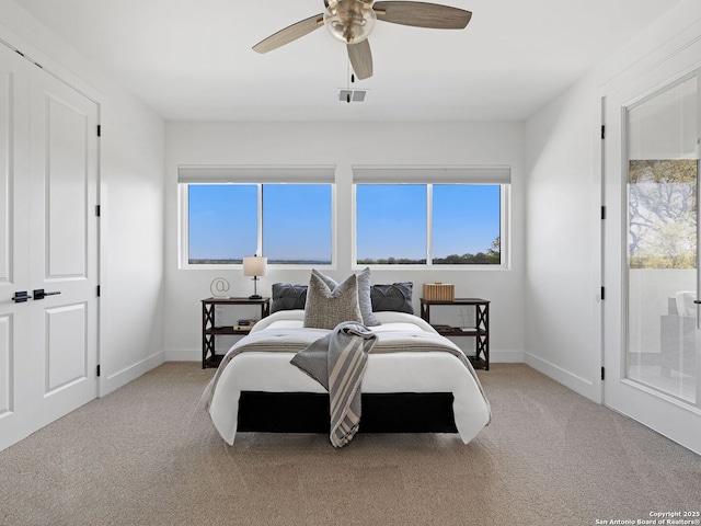carpeted bedroom with access to outside, ceiling fan, visible vents, and baseboards
