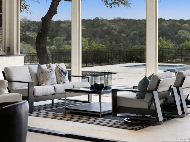 exterior space featuring fence, an outdoor living space, a wooded view, and a fenced in pool