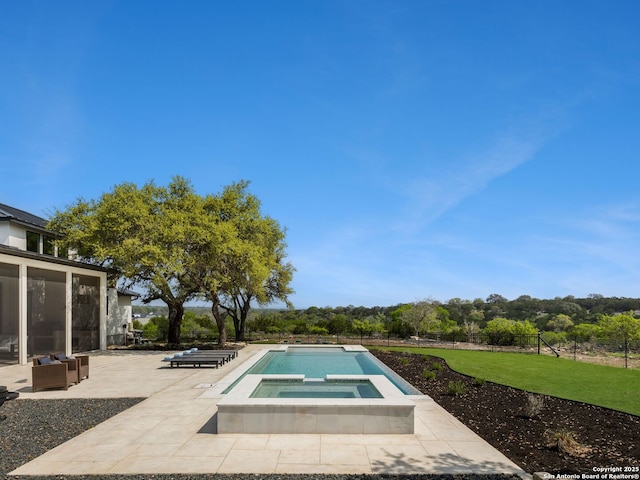 pool with an in ground hot tub, a patio area, and a yard