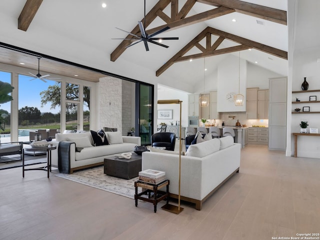 living room with beam ceiling, high vaulted ceiling, light wood-style flooring, ceiling fan with notable chandelier, and recessed lighting