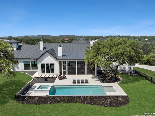 back of property featuring a lawn, a fenced backyard, a chimney, and a standing seam roof