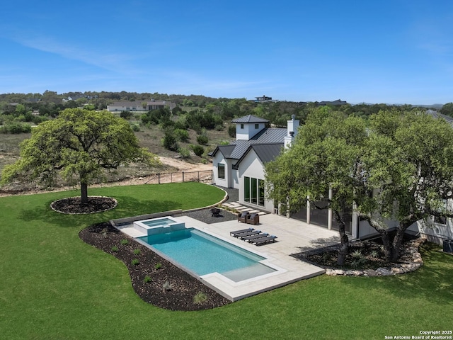 view of pool featuring a lawn, a fenced backyard, a pool with connected hot tub, and a patio