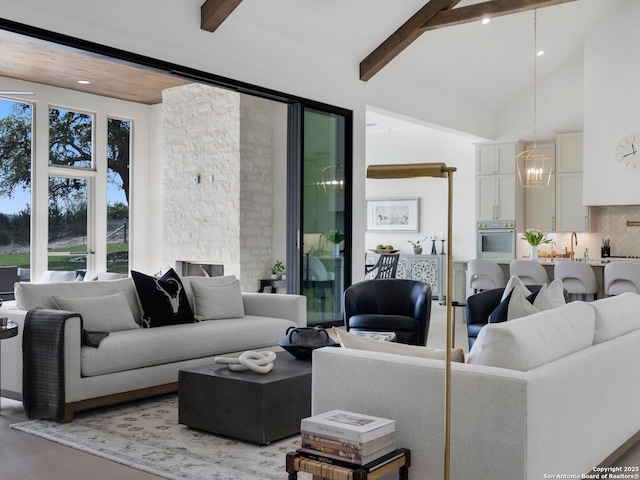 living area with light wood-style floors, high vaulted ceiling, beamed ceiling, and a notable chandelier