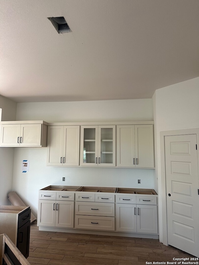 434 Hanging Oak, Spring Branch, TX 78070 - kitchen featuring wood finished floors and glass insert cabinets