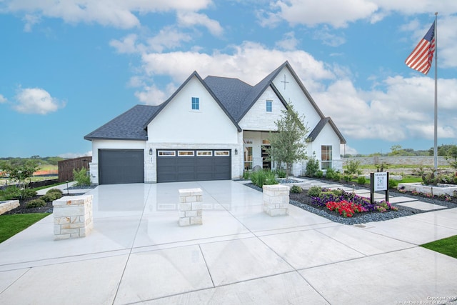 view of front of house featuring roof with shingles, stone siding, a garage, stucco siding, and driveway