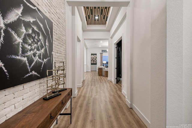 corridor featuring baseboards and wood finished floors