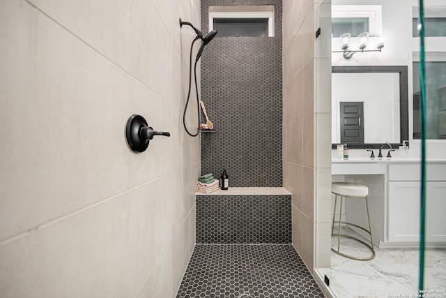 bathroom featuring a tile shower and vanity