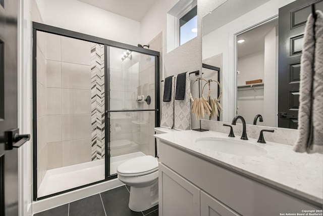bathroom featuring vanity, toilet, tile patterned flooring, and a stall shower