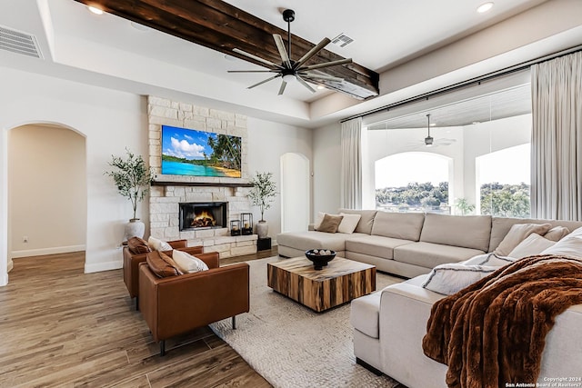 living room featuring arched walkways, ceiling fan, visible vents, and wood finished floors