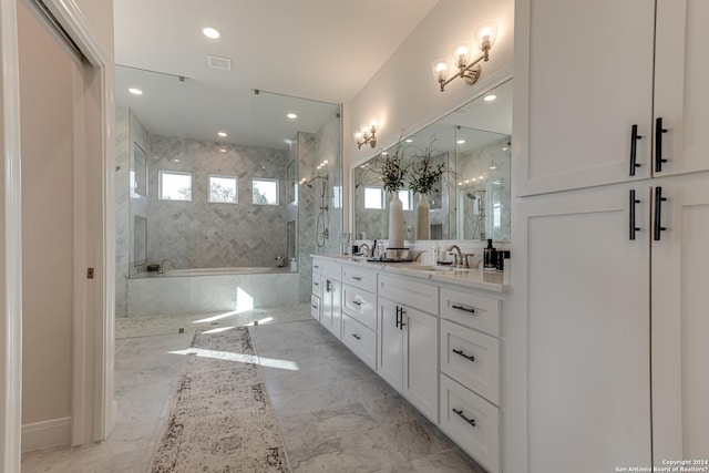 full bath with double vanity, a tub with marble appearance, a sink, marble finish floor, and a marble finish shower