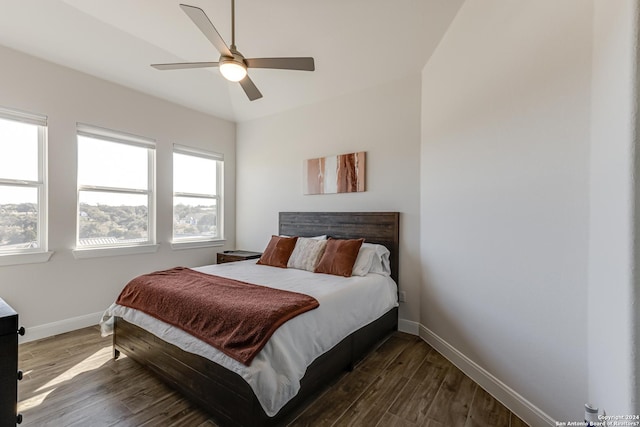 bedroom featuring baseboards, a ceiling fan, and dark wood-style flooring