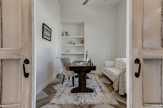 sitting room with a ceiling fan, baseboards, and built in shelves