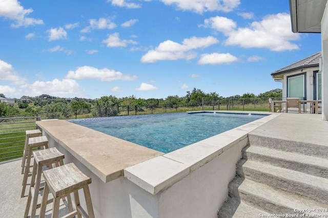 view of pool featuring a fenced in pool, outdoor dry bar, and fence