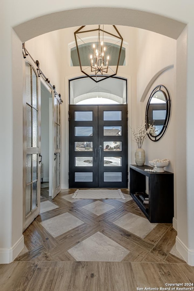 foyer featuring french doors, baseboards, and a chandelier