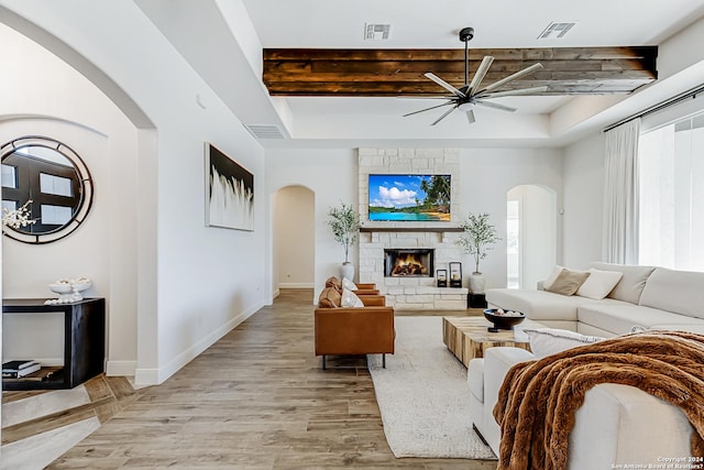 living area with visible vents, arched walkways, ceiling fan, and a healthy amount of sunlight