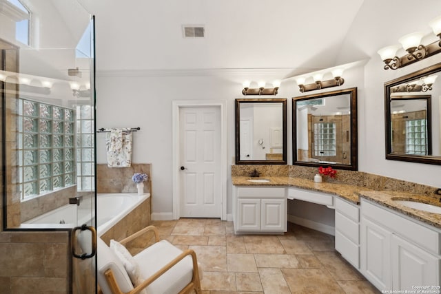 bathroom featuring tiled bath, healthy amount of natural light, double vanity, and a tile shower