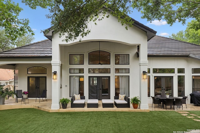 back of house featuring french doors, a lawn, a patio area, and stucco siding