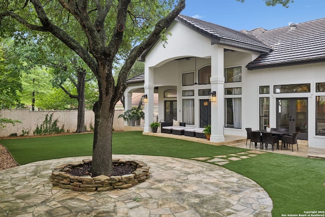 back of property featuring french doors, a patio area, stucco siding, and a tiled roof