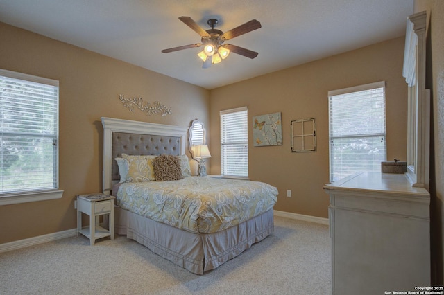 bedroom with baseboards, ceiling fan, and light carpet