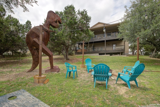 view of playground featuring an outdoor fire pit and a yard