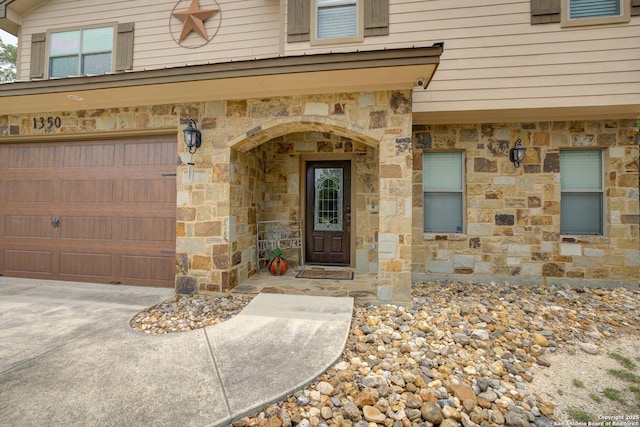 doorway to property with stone siding and a garage