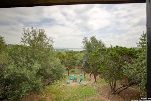 exterior space featuring fence and a wooded view