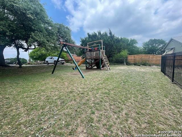 view of yard featuring a playground and fence