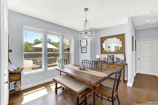 dining space with visible vents, baseboards, and dark wood-type flooring