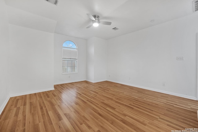 empty room featuring ceiling fan, baseboards, visible vents, and light wood-style flooring
