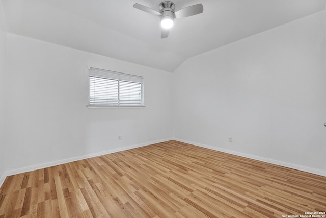 empty room featuring light wood-style floors, baseboards, ceiling fan, and lofted ceiling