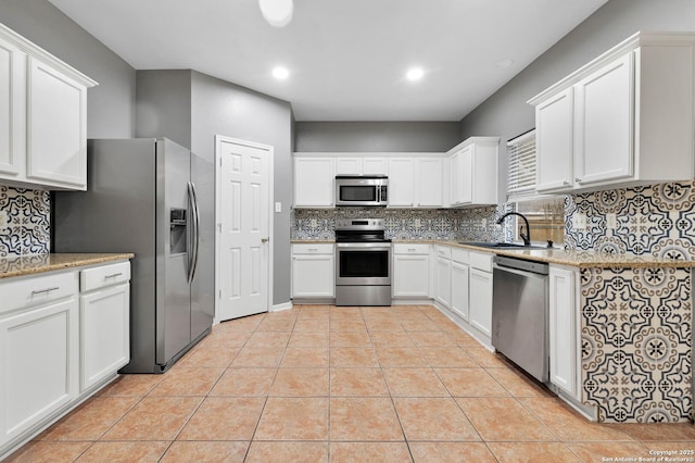 kitchen featuring a sink, light tile patterned floors, backsplash, and stainless steel appliances