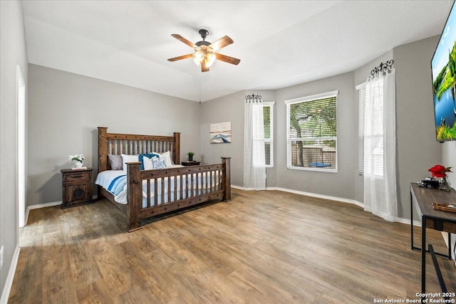 bedroom with baseboards, a ceiling fan, and wood finished floors