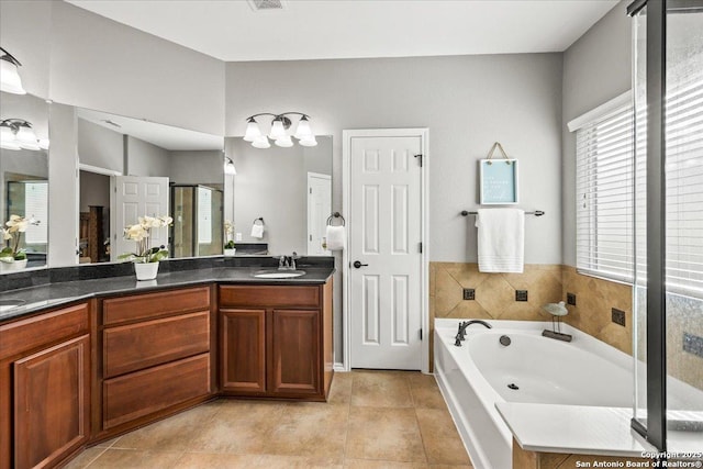 bathroom featuring double vanity, a garden tub, tile patterned flooring, a stall shower, and a sink