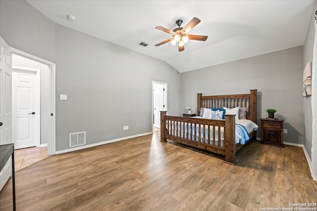 bedroom featuring vaulted ceiling, wood finished floors, and visible vents