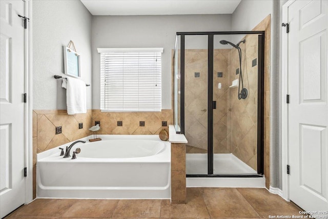 bathroom with a garden tub, tile patterned floors, and a shower stall