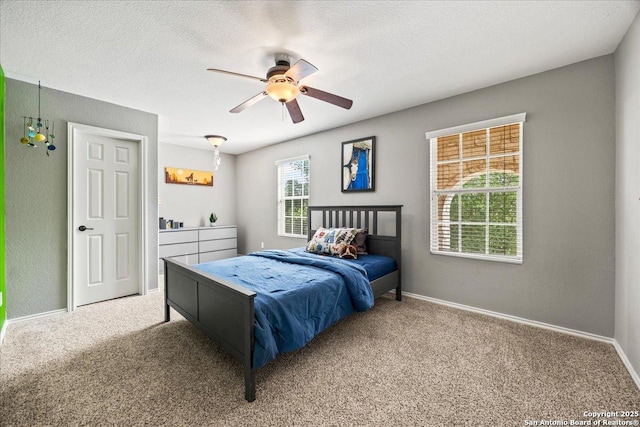 bedroom with carpet flooring, a textured ceiling, baseboards, and ceiling fan