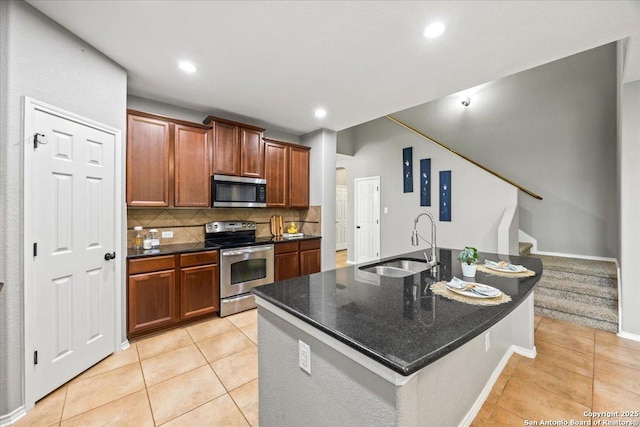 kitchen with light tile patterned flooring, appliances with stainless steel finishes, a sink, recessed lighting, and decorative backsplash