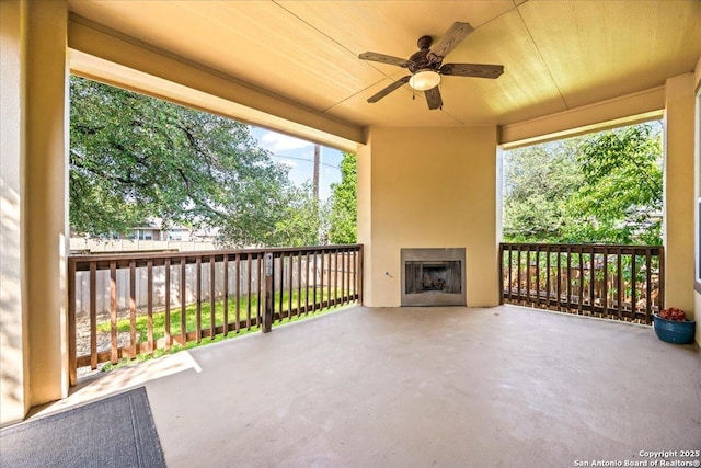 view of patio with a ceiling fan and exterior fireplace