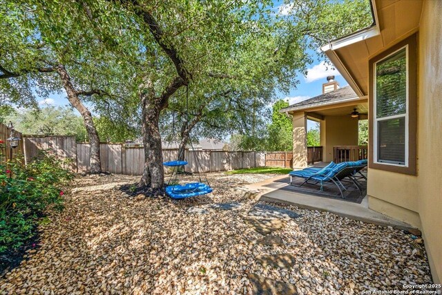 view of yard with a fenced backyard, a ceiling fan, and a patio