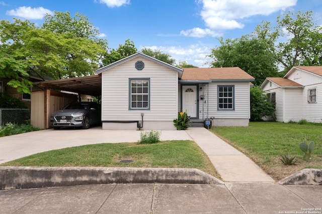 view of front of house with fence, driveway, a front lawn, and a carport