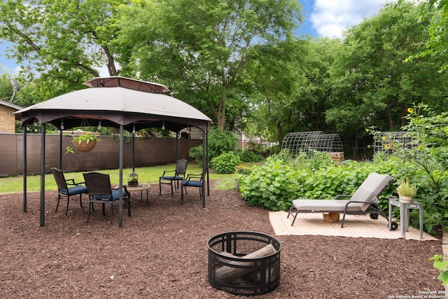view of patio featuring a gazebo, a garden, and a fenced backyard