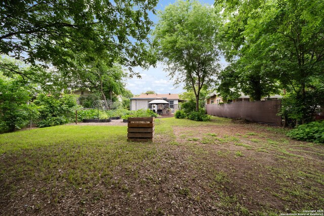 view of yard with fence and a garden
