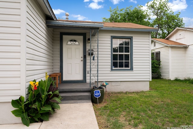 doorway to property featuring a lawn